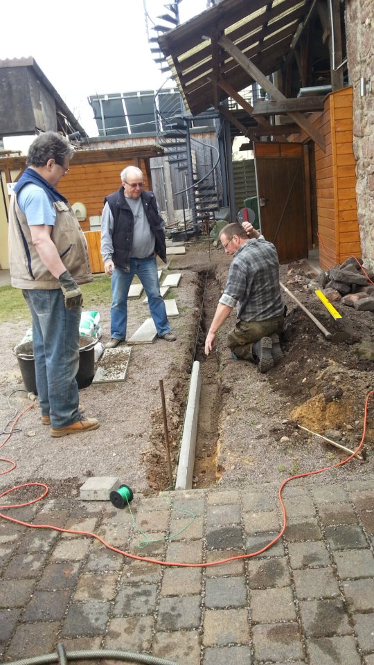 Setzen von Randsteinen hinter dem Kelterhaus. 