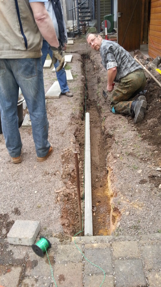 Setzen von Randsteinen hinter dem Kelterhaus. 