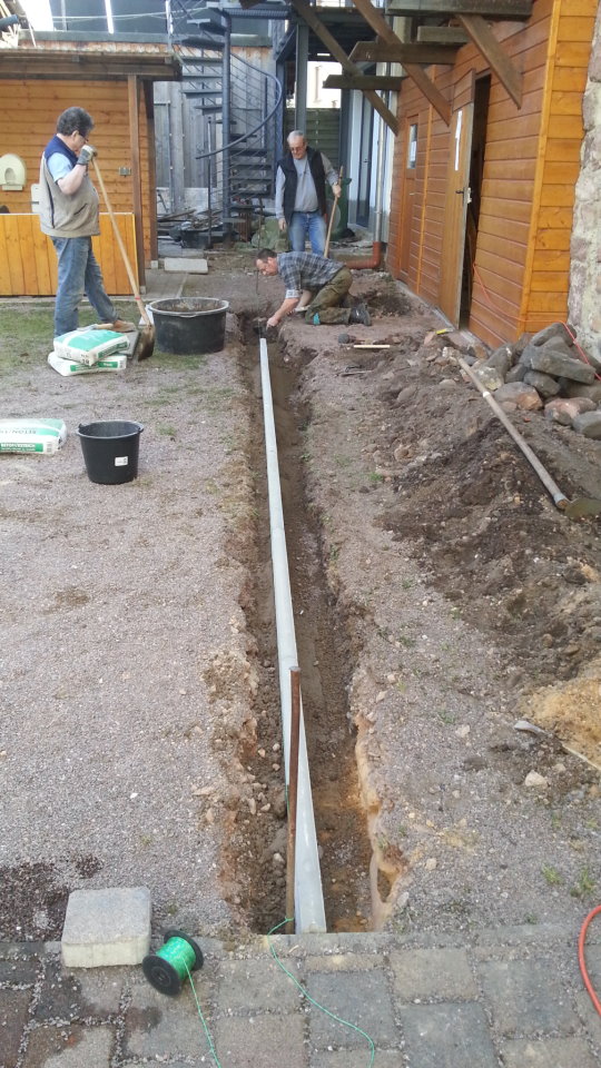 Setzen von Randsteinen hinter dem Kelterhaus. 