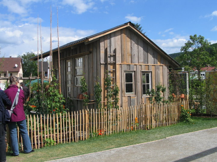 Aus Altmaterial gebaute Gartenlaube